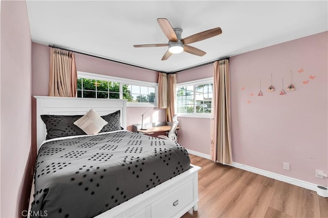 bedroom with light wood finished floors, baseboards, and ceiling fan