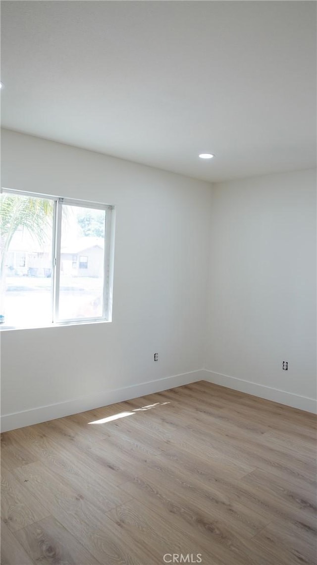 empty room featuring baseboards, recessed lighting, and light wood-style flooring