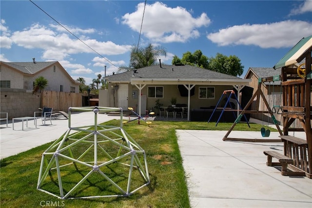 back of house with fence, stucco siding, a playground, a patio area, and a yard