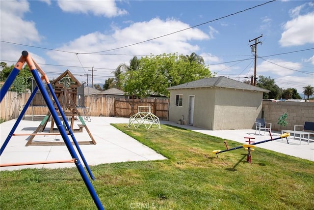 view of yard featuring a patio, a fenced backyard, a playground, and an outbuilding