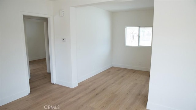 empty room featuring baseboards and light wood-type flooring
