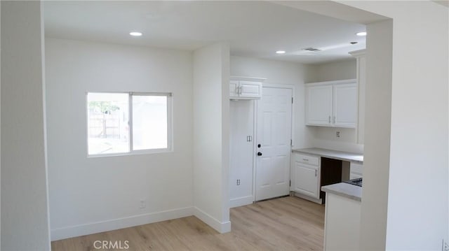 kitchen featuring visible vents, light countertops, baseboards, light wood-style floors, and white cabinetry