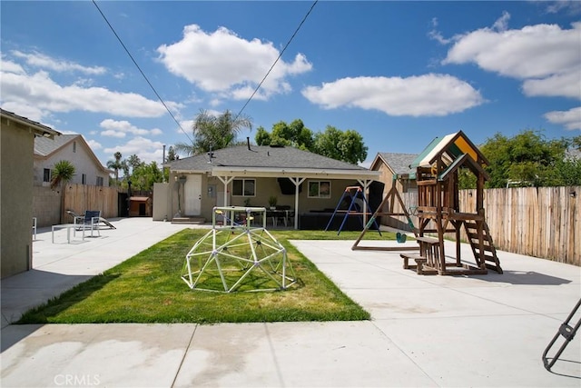 view of play area featuring a lawn, a patio, and fence