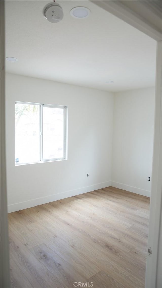 empty room featuring light wood-style floors and baseboards