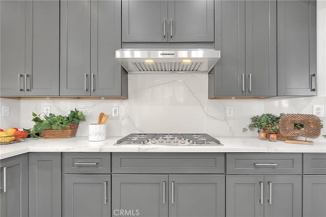 kitchen featuring gray cabinets, tasteful backsplash, range hood, and stainless steel gas cooktop