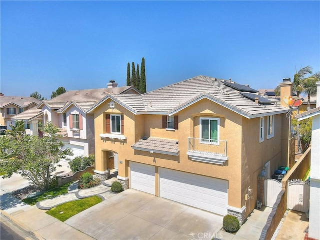 view of front of house featuring a garage, a chimney, concrete driveway, stucco siding, and a gate