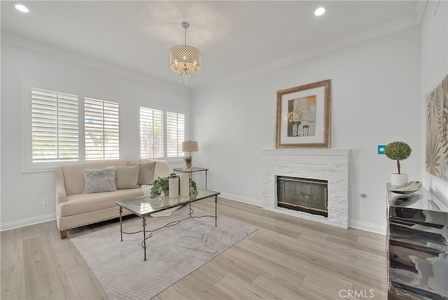 living area with a notable chandelier, ornamental molding, recessed lighting, a fireplace, and wood finished floors