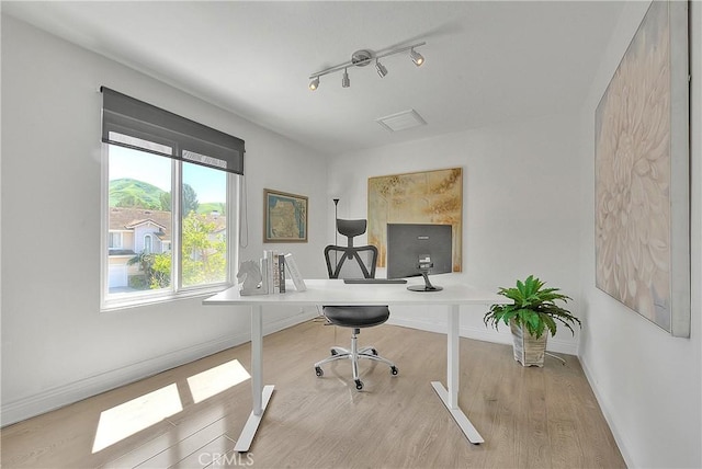 office space with track lighting, baseboards, and wood finished floors