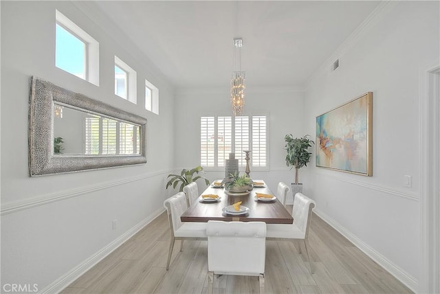 dining area with crown molding, baseboards, a notable chandelier, and wood finished floors