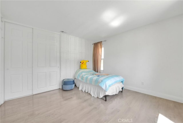 bedroom featuring wood finished floors, baseboards, and visible vents