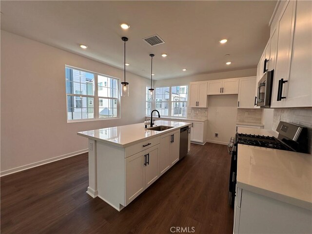4450 S Bryant Paseo, Ontario, CA 91762 - kitchen with dark wood finished floors, visible vents, appliances with stainless steel finishes, a sink, and decorative backsplash