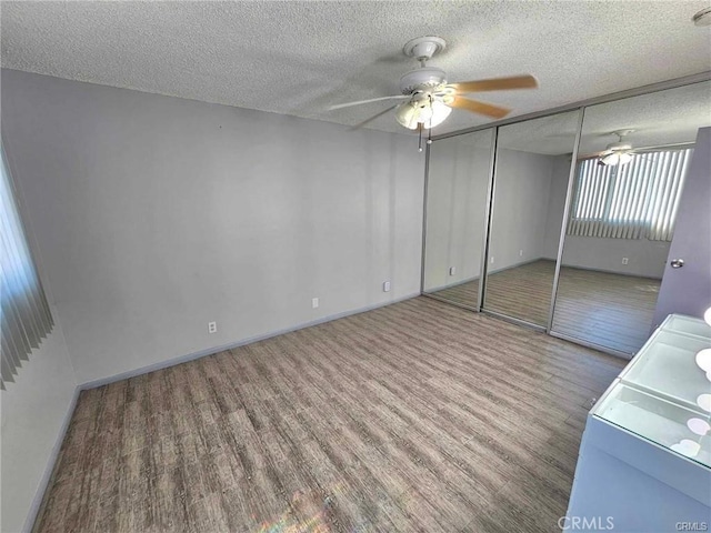 6979 Palm Ct Unit 126H, Riverside, CA 92506 - unfurnished bedroom with a closet, baseboards, wood finished floors, and a textured ceiling
