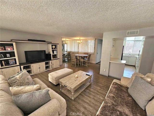 6979 Palm Ct Unit 126H, Riverside, CA 92506 - living room with a notable chandelier, visible vents, a textured ceiling, and wood finished floors