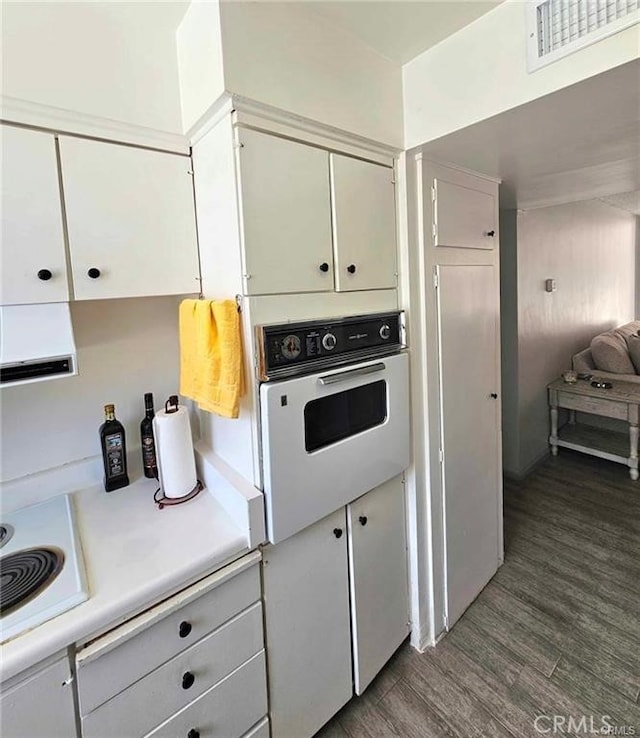 6979 Palm Ct Unit 126H, Riverside, CA 92506 - kitchen with visible vents, light countertops, white appliances, white cabinetry, and wood finished floors