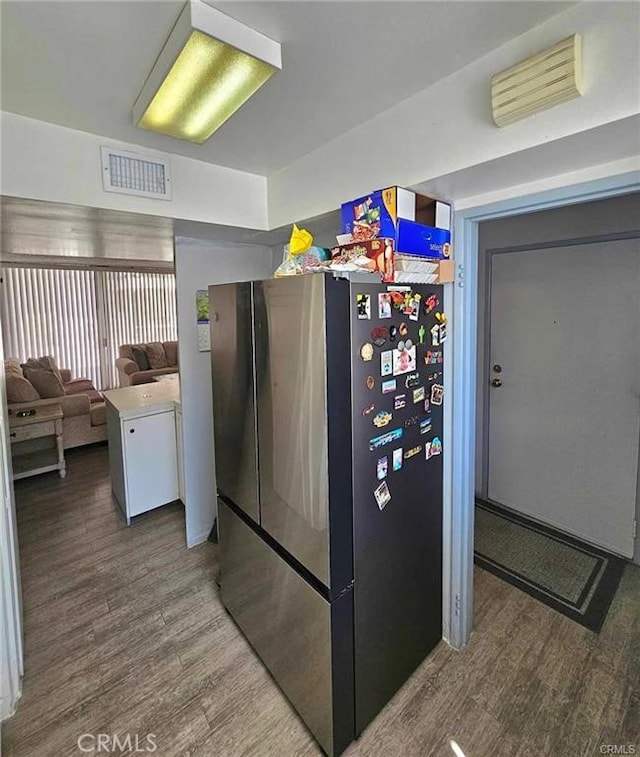 6979 Palm Ct Unit 126H, Riverside, CA 92506 - interior space featuring wood finished floors, freestanding refrigerator, and visible vents