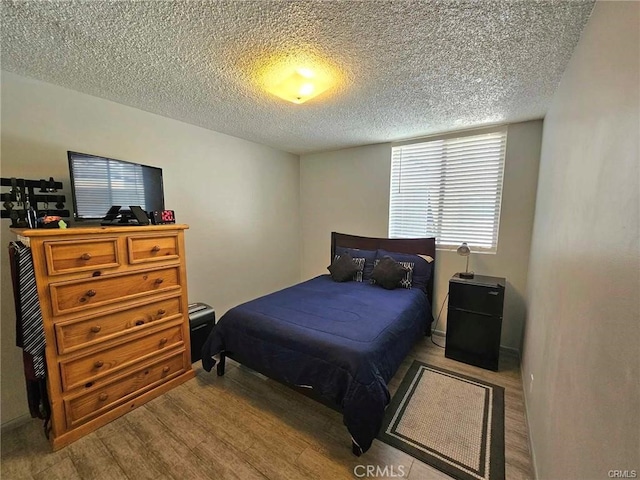 6979 Palm Ct Unit 126H, Riverside, CA 92506 - bedroom with a textured ceiling and wood finished floors