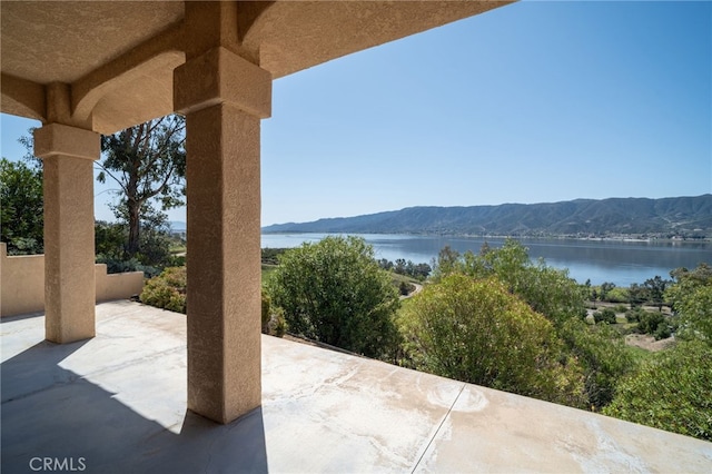 view of patio with a water and mountain view