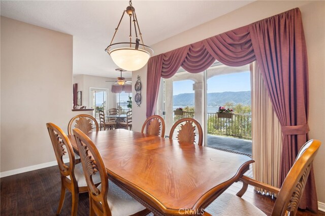 dining room featuring a mountain view, baseboards, and dark wood finished floors