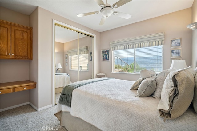 bedroom with a closet, light colored carpet, baseboards, and multiple windows