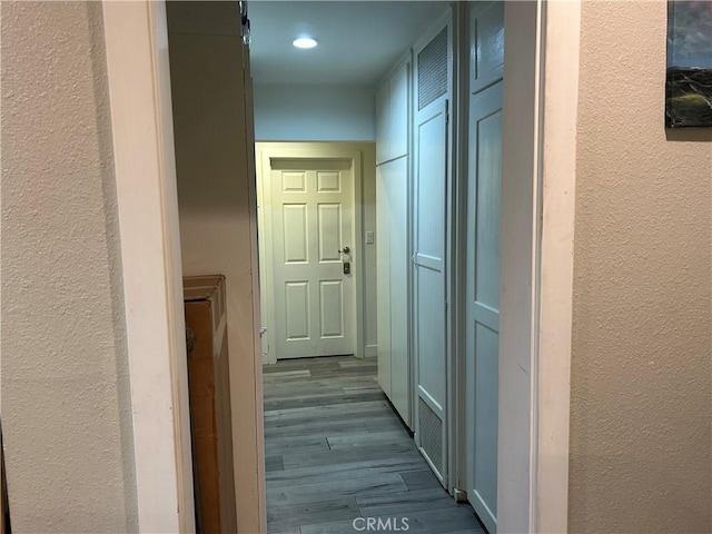 14615 Wyandotte St, Van Nuys, CA 91405 - corridor with dark wood-style flooring, a textured wall, and recessed lighting