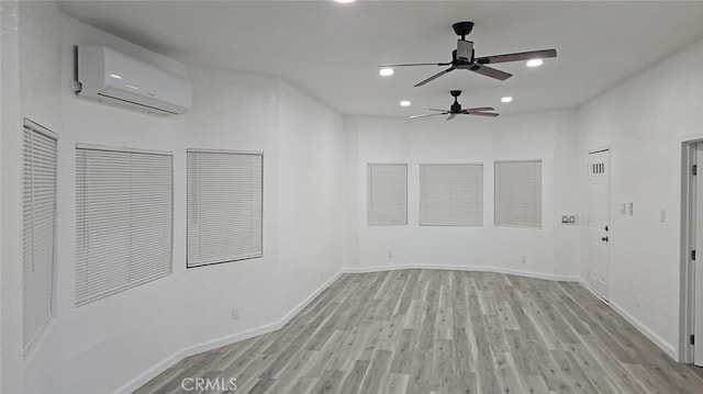 spare room featuring baseboards, an AC wall unit, ceiling fan, recessed lighting, and wood finished floors