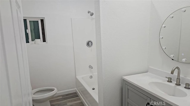 bathroom featuring vanity,  shower combination, toilet, wood finished floors, and baseboards