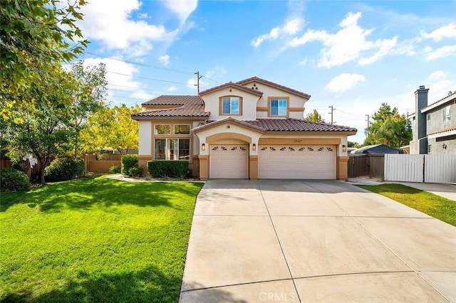 mediterranean / spanish house with stucco siding, driveway, a front lawn, a tiled roof, and fence
