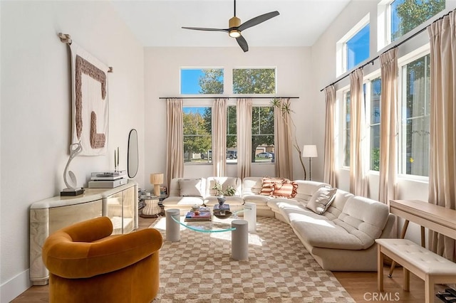 living area featuring light wood-style floors and a ceiling fan