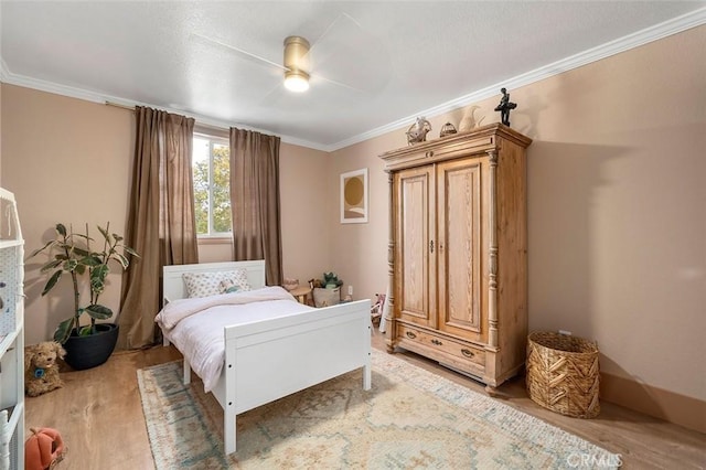 bedroom with crown molding, a ceiling fan, and wood finished floors