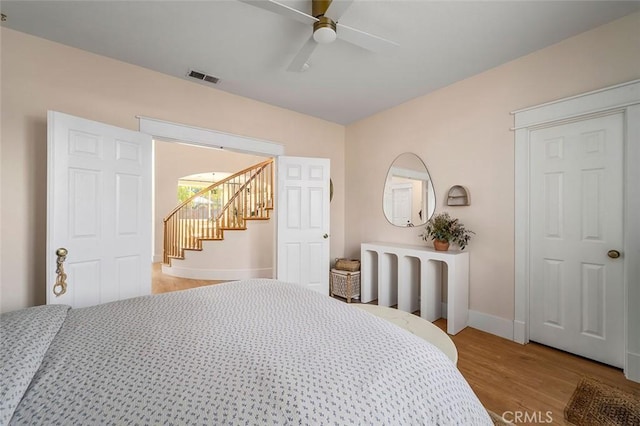 bedroom featuring visible vents, baseboards, light wood finished floors, and ceiling fan