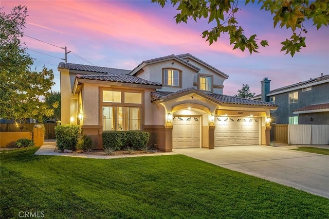 mediterranean / spanish house with fence, driveway, and stucco siding