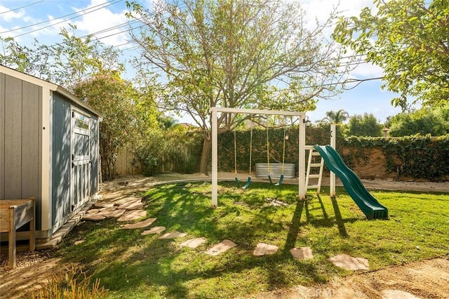 view of jungle gym with a fenced backyard, an outdoor structure, and a lawn