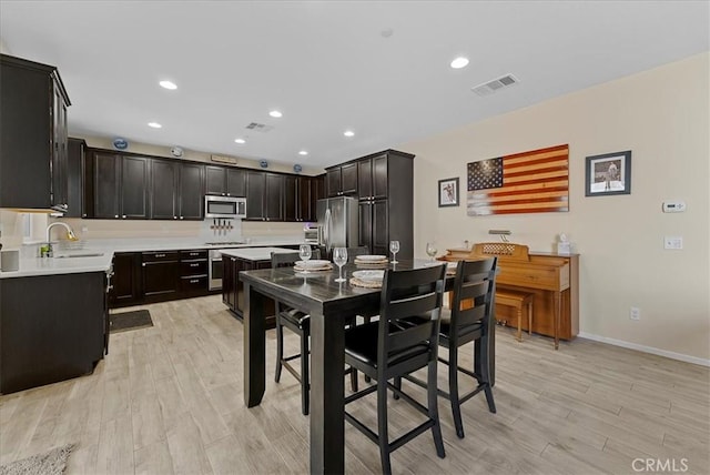 10969 Elkwood Cir, Riverside, CA 92503 - kitchen with stainless steel appliances, light countertops, light wood-type flooring, baseboards, and a sink