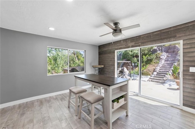 1080 1st St, Norco, CA 92860 - dining room with wooden walls, ceiling fan, light wood-style floors, and baseboards