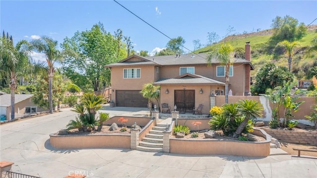 1080 1st St, Norco, CA 92860 - rear view of house with a garage, stucco siding, fence, a chimney, and concrete driveway