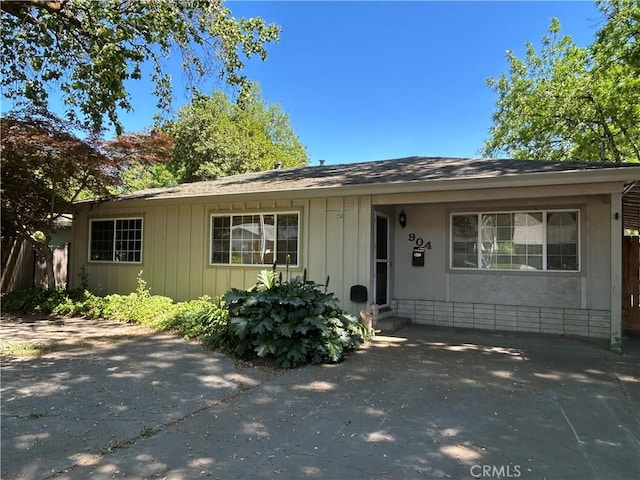 single story home with roof with shingles and board and batten siding