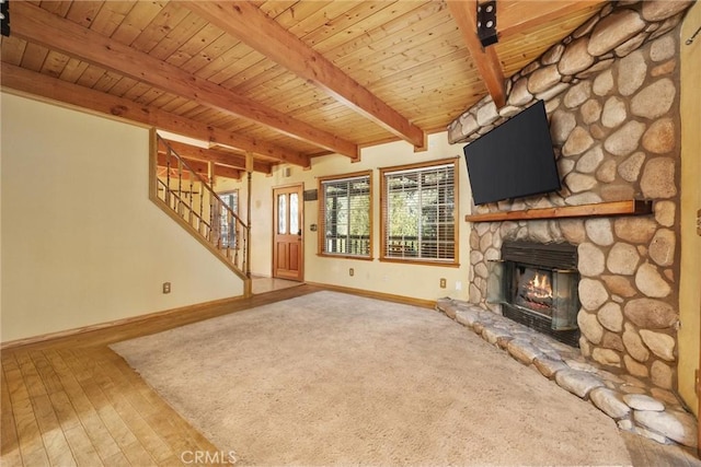 14521 Voltaire Dr, Pine Mountain Club, CA 93222 - unfurnished living room with baseboards, wood ceiling with exposed beams, a stone fireplace, stairway, and wood finished floors