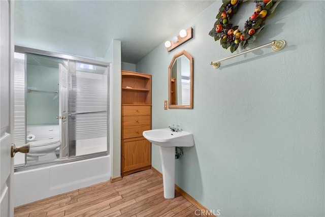14521 Voltaire Dr, Pine Mountain Club, CA 93222 - bathroom featuring wood finished floors, enclosed tub / shower combo, toilet, and baseboards