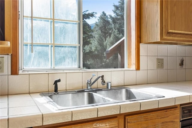 14521 Voltaire Dr, Pine Mountain Club, CA 93222 - kitchen with a sink, tile counters, brown cabinets, and backsplash