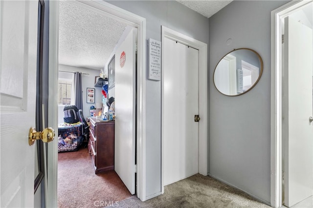 hallway featuring carpet flooring and a textured ceiling