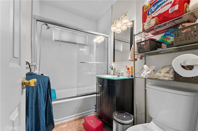 bathroom with bath / shower combo with glass door, vanity, and toilet
