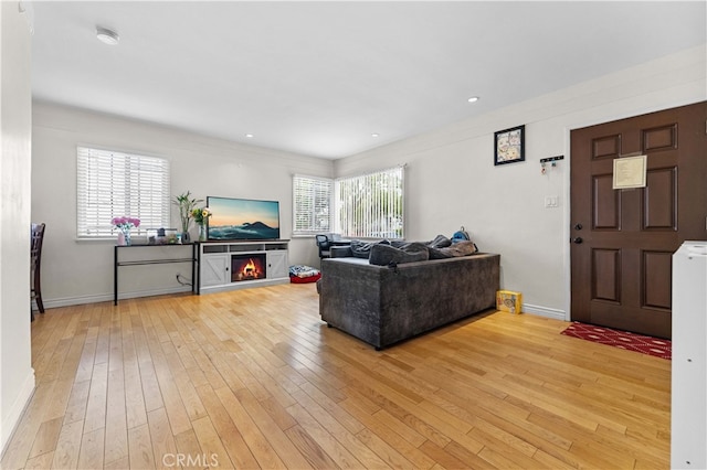living room featuring baseboards, light wood finished floors, and recessed lighting