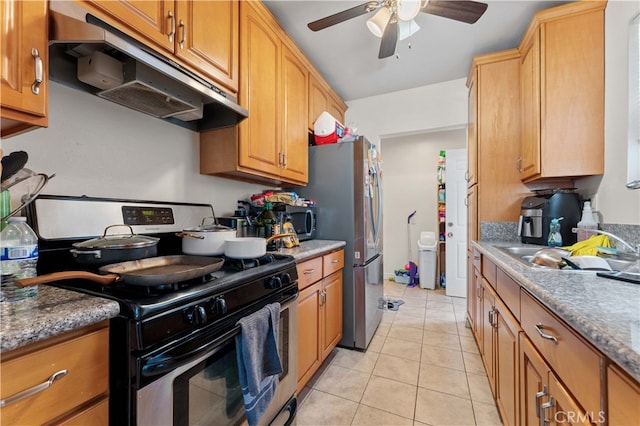 kitchen featuring light tile patterned floors, a ceiling fan, under cabinet range hood, a sink, and stainless steel appliances