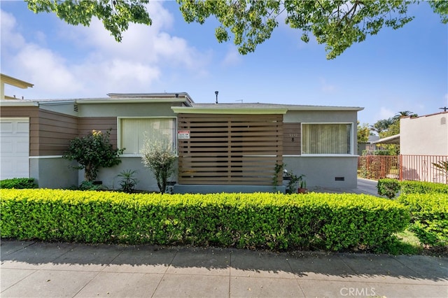view of front of home with stucco siding and an attached garage