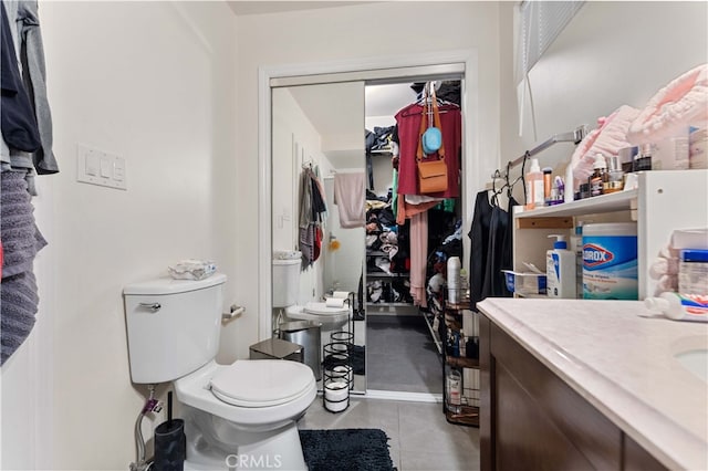 bathroom with tile patterned flooring, vanity, and toilet