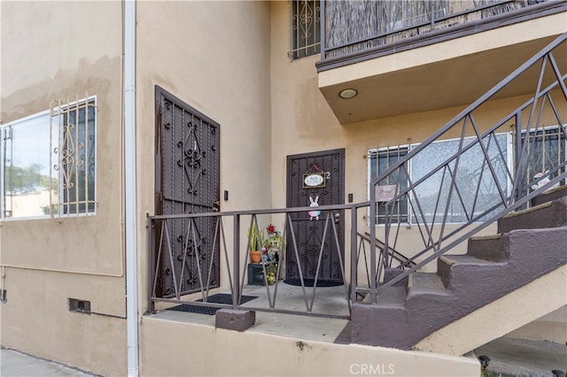 doorway to property featuring stucco siding