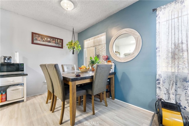 dining space featuring a textured ceiling and wood finished floors