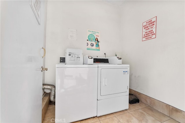 washroom featuring washing machine and dryer and tile patterned flooring