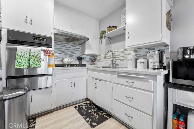 kitchen featuring white cabinets, open shelves, oven, a sink, and under cabinet range hood