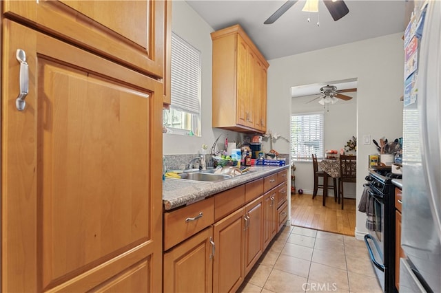 kitchen featuring a sink, light tile patterned floors, ceiling fan, and range with gas stovetop